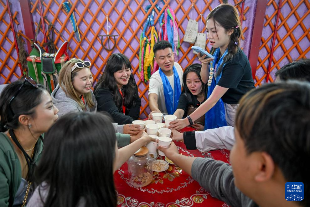 8月22日，在內(nèi)蒙古烏蘭察布市輝騰錫勒草原，參加第三十屆海峽兩岸大學(xué)生新聞營(yíng)的師生在蒙古包裡喝奶茶。新華社記者 連振 攝